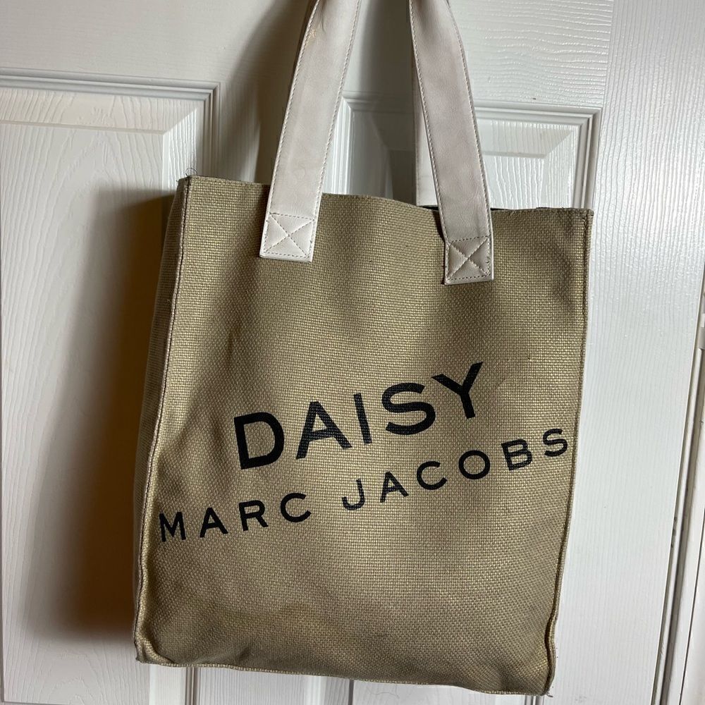 Marc Jacobs Daisy Parfums burlap gold tote bag with white faux leather straps .